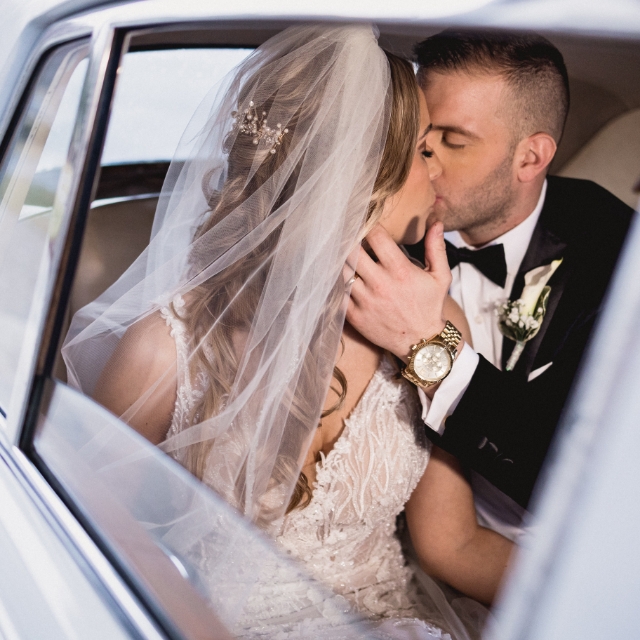 Photo of Kissing Newlyweds In A Car