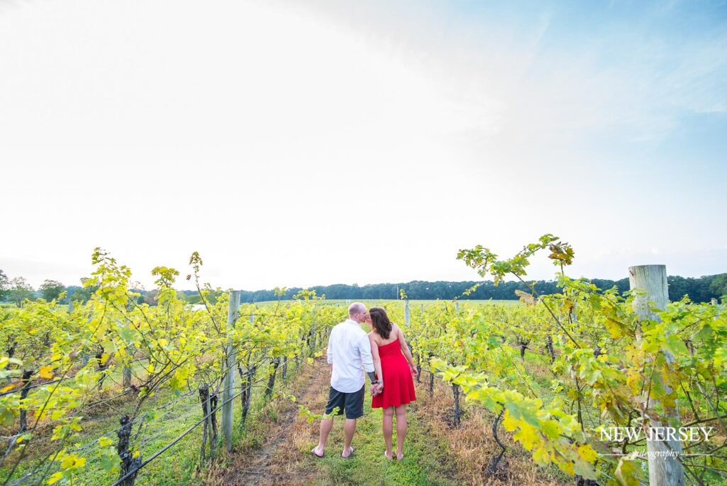 Playful engagement photo of a couple running through tall grass
