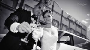 bw picture of newlyweds holding glasses of champagne