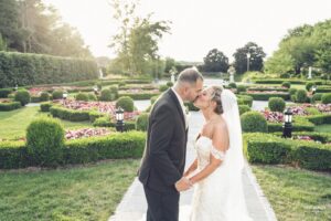 Bride and groom sharing a kiss in a beautifully landscaped garden