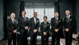 Groom standing with his groomsmen in formal suits