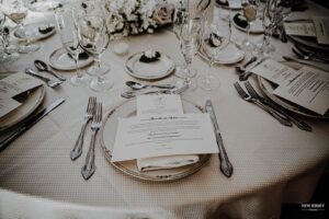 Elegantly set wedding reception table with invitations and glassware
