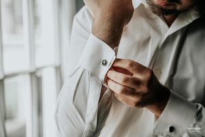 Close-up of a groom adjusting his cufflinks