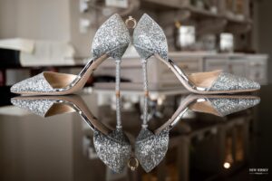 Pair of glittering bridal heels reflected on a shiny surface