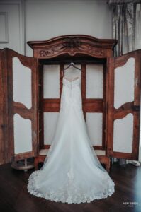 Bridal gown hanging in an open antique wardrobe