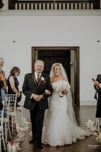 Bride walking down the aisle arm-in-arm with her father during the wedding ceremony